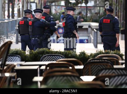 Paris, France. 2nd juillet 2023. Des policiers français patrouillent dans la célèbre avenue des champs-Élysées à Paris, en France, en 2 juillet 2023. Au moins 719 personnes ont été arrêtées pendant la nuit de samedi à dimanche en France, la cinquième nuit de violence nationale déclenchée par le meurtre d'un adolescent par un policier, a déclaré dimanche le ministère de l'intérieur français. Selon le ministère, 45 policiers et gendarmes ont été blessés, tandis que 577 véhicules et 74 bâtiments ont été brûlés. Credit: Gao Jing/Xinhua/Alamy Live News Banque D'Images