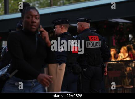 Paris, France. 2nd juillet 2023. Des policiers français patrouillent dans la célèbre avenue des champs-Élysées à Paris, en France, en 2 juillet 2023. Au moins 719 personnes ont été arrêtées pendant la nuit de samedi à dimanche en France, la cinquième nuit de violence nationale déclenchée par le meurtre d'un adolescent par un policier, a déclaré dimanche le ministère de l'intérieur français. Selon le ministère, 45 policiers et gendarmes ont été blessés, tandis que 577 véhicules et 74 bâtiments ont été brûlés. Credit: Gao Jing/Xinhua/Alamy Live News Banque D'Images