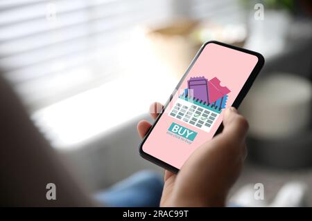 Femme achetant des billets en ligne par téléphone mobile à la maison, gros plan Banque D'Images