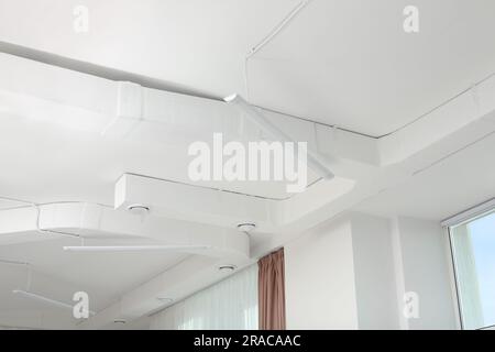 Plafond blanc avec éclairage moderne dans le bureau Banque D'Images