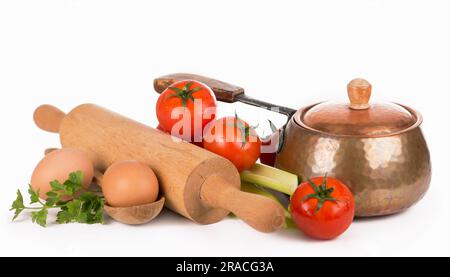poêle en cuivre, rollpin, cuillères et différents légumes crus sur fond blanc Banque D'Images