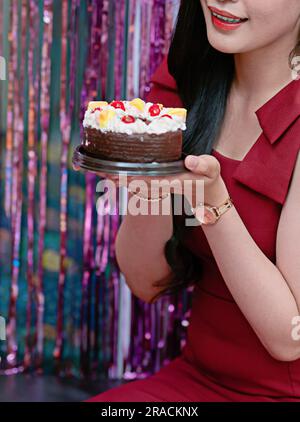 Main de fille tenant un gâteau d'anniversaire Focus sur les moments heureux Banque D'Images