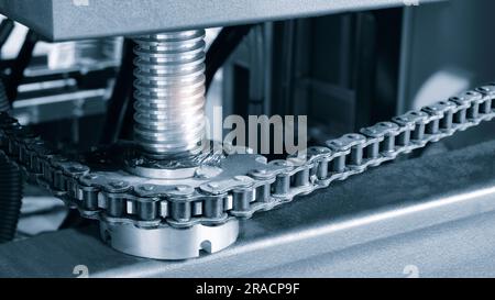 L'arbre d'entraînement de la chaîne d'engrenages de la courroie du convoyeur se trouve sur la chaîne de production. Chaîne de distribution du véhicule, tendeurs dans le moteur. Chaîne à rouleaux industrielle, technologie. L'équipe va Banque D'Images