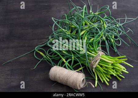 Flèches à l'ail. Un bouquet de verts sur la table. Alimentation en vitamines saine végétale. Tiges vertes de tiges plantules pour la salade et le ragoût. Herbes fraîches végétariennes, cuisine chinoise. Banque D'Images