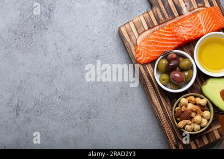 Sources alimentaires de gras insaturés sains et d'oméga 3 : filet de saumon frais, avocat, olives et noix Banque D'Images