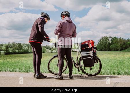 Deux cyclistes consultent la carte sur la route Romantische Strasse, en Allemagne Banque D'Images