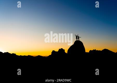 Grimpeurs dans le parc national de Joshua Tree au coucher du soleil Banque D'Images