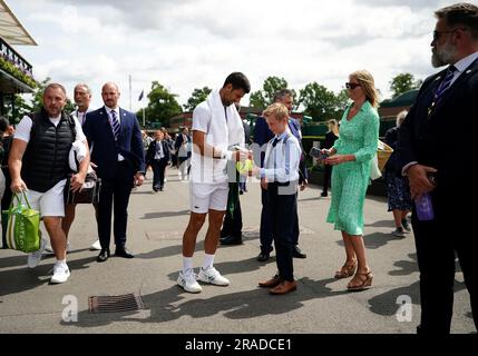 Novak Djokovic signe une balle de tennis géante pour un fan alors qu'il marche sur le terrain après s'être exercé sur les courts extérieurs le premier jour des championnats de Wimbledon 2023 au All England Lawn tennis and Croquet Club de Wimbledon. Date de la photo: Lundi 3 juillet 2023. Banque D'Images