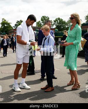 Novak Djokovic signe une balle de tennis géante pour un fan alors qu'il marche sur le terrain après s'être exercé sur les courts extérieurs le premier jour des championnats de Wimbledon 2023 au All England Lawn tennis and Croquet Club de Wimbledon. Date de la photo: Lundi 3 juillet 2023. Banque D'Images