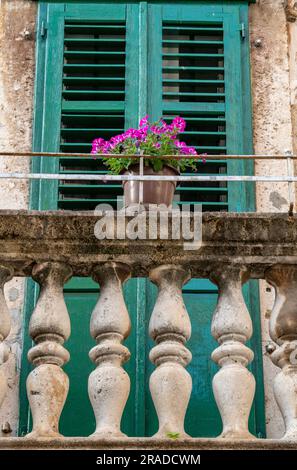 attrayant shabby chic volets verts peints et balustrade balcon en pierre sur un bâtiment ancien et historique à split, croatie Banque D'Images
