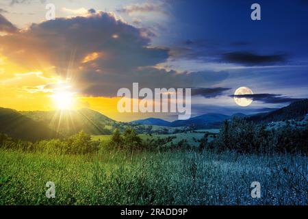 concept de changement d'heure de jour et de nuit. Prairie alpine avec de l'herbe haute sur un fond de montagnes avec le soleil et la lune au crépuscule Banque D'Images