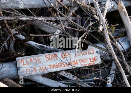 Panneau d'avertissement de plage pour le bois flotté dans la région côtière de Takaka sur Golden Bay à la frontière du parc national Abel Tasman sur l'île du Sud, en Nouvelle-Zélande Banque D'Images