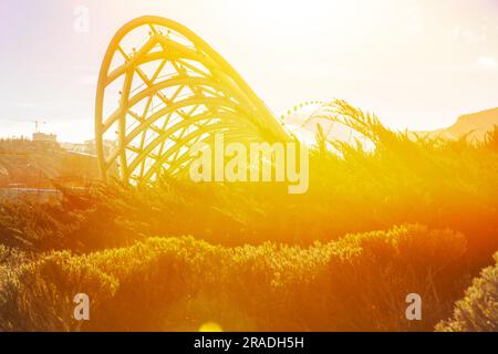 Pont de paix de Tbilissi au crépuscule. Bridge of Peace est Un pont piétonnier en forme d'arc au-dessus de la rivière Kura à Tbilissi, capitale de la Géorgie, reliant Rike Banque D'Images