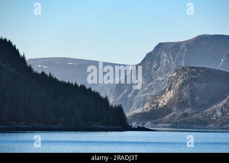 Fjord avec montagnes à l'horizon. L'eau écoute le soleil en Norvège. Photo de paysage du nord Banque D'Images