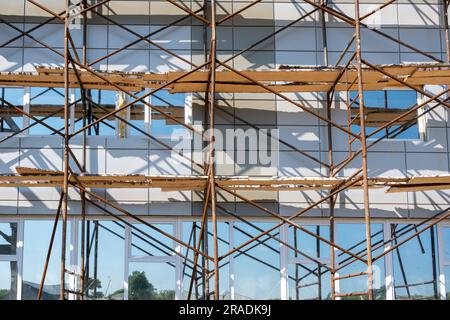 Bâtiment en construction. Fragment d'échafaudage contre le mur de la maison. Maisons résidentielles en construction. Échafaudage sur le mur du bâtiment sur le bâtiment Banque D'Images