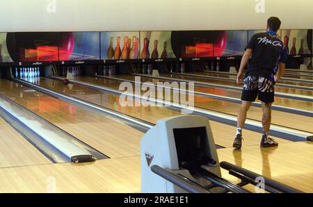 Un homme roule une balle pour essayer de faire tomber les quilles sur le terrain de bowling à dix quilles de Jomtien Palm Beach Hotel & Resort, Jomtien, Pattaya, Thaïlande Banque D'Images