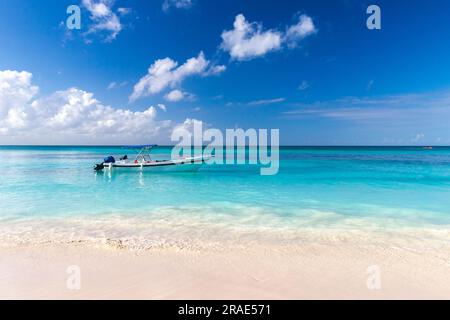 Paysage côtier des Caraïbes avec bateau de pêche ancré près de la côte de sable vide de l'océan Atlantique par une journée ensoleillée. République dominicaine. Plage de Bavaro Banque D'Images