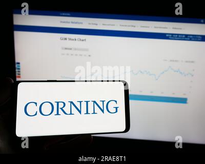 Personne tenant un téléphone portable avec le logo de la société technologique américaine Corning Incorporated sur l'écran devant la page Web. Concentrez-vous sur l'affichage du téléphone. Banque D'Images