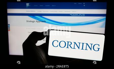 Personne détenant un smartphone avec le logo de la société technologique américaine Corning Incorporated sur l'écran devant le site Web. Concentrez-vous sur l'affichage du téléphone. Banque D'Images