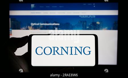 Personne tenant un téléphone portable avec le logo de la société de technologie américaine Corning Incorporated sur l'écran devant la page Web de l'entreprise. Concentrez-vous sur l'affichage du téléphone. Banque D'Images