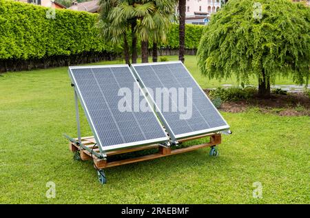 Panneaux photovoltaïques mouillés par la pluie sur la palette en bois dans le jardin de la maison. Concept d'énergie verte. Banque D'Images