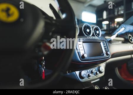 05.17.2023 Varsovie, Pologne. Concept d'habillage de voiture d'intérieur. Luxueux cockpit de voiture de sport étant nettoyé en détaillant expert avec une petite brosse. Photo de haute qualité Banque D'Images