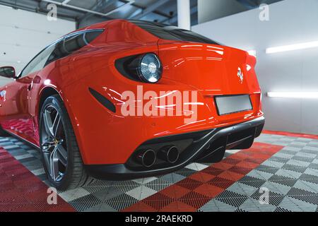05.17.2023 Varsovie, Pologne. Vue arrière d'une Ferrari de luxe rouge garée chez le mécanicien ou dans un studio d'esthétique automobile. Peinture de voiture rouge brillante d'une voiture de sport. Photo de haute qualité Banque D'Images