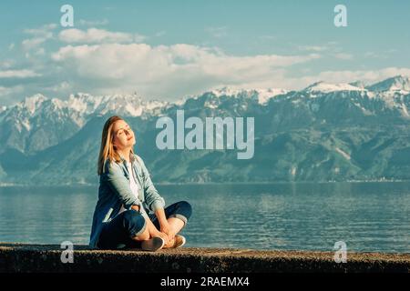 Portrait en plein air de la jeune femme heureuse se relaxant au bord du lac par une belle journée ensoleillée, paisible et harmonieuse humeur Banque D'Images