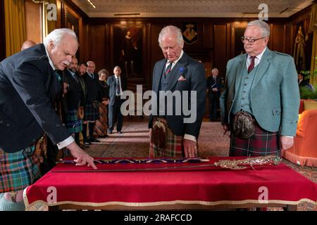 Le roi Charles III avec le designer Mark Dennis (à gauche), Lord Lyon (à droite) et la nouvelle épée Elizabeth au Palais de Holyroodhouse à Édimbourg. L'épée nommée d'après la reine Élisabeth II fera partie des distinctions honorifiques de l'Écosse, qui comprend la Couronne et le Scepter, sera présentée au roi lors du service national de Thanksgiving et de l'inauguration à la cathédrale Saint-Giles le mercredi 5 juillet. Date de la photo: Lundi 3 juillet 2023. Banque D'Images