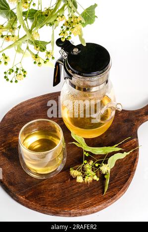 Théière en verre avec thé de linden filtre et verre transparent sur fond blanc. Vue de dessus. Banque D'Images