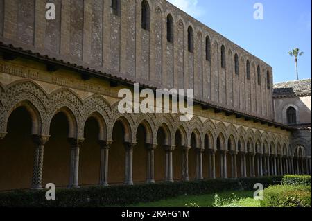 Arches et colonnes de style arabo-normand avec des chapîtres sculptés de style roman à l'extérieur du cloître bénédictin de Monreale en Sicile, Italie. Banque D'Images