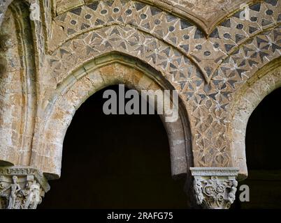 Arches et colonnes de style normand arabesques avec chapiteaux sculptés de style roman à l'extérieur du cloître bénédictin de Monreale en Sicile Banque D'Images