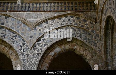 Arches et colonnes de style normand arabesques avec chapiteaux sculptés de style roman à l'extérieur du cloître bénédictin de Monreale en Sicile Banque D'Images