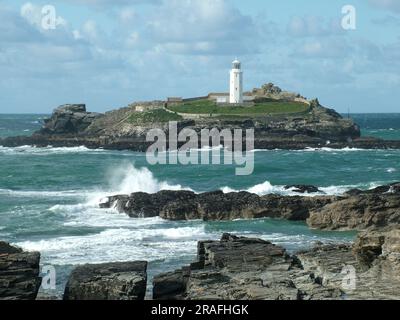 La lumière du soleil d'automne illumine la tour octogonale blanche de 26 mètres du phare de Godrevy. Construit à la fin des années 1850 et habité par trois gardiens de phare, Banque D'Images