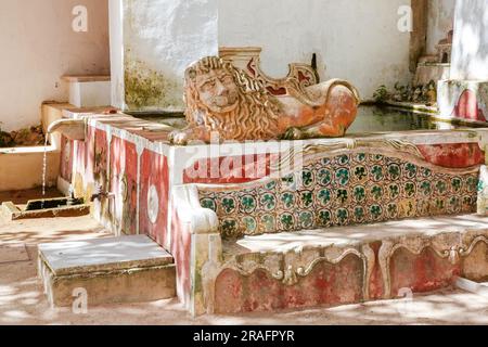 Une statue de lion en céramique et une salle de bains extérieure décorées de carreaux azulejos sur la terrasse du jardin Preta du Palais national de Sintra, au Portugal. Les palais architecturaux et de conte de fées Romanticistes attirent des touristes du monde entier. Banque D'Images