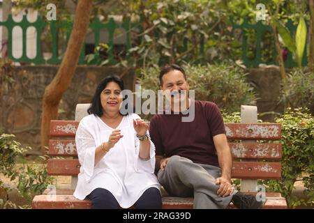 Beau vieux couple heureux indien assis ensemble dans le parc et ayant des moments joyeux de la vie. Banque D'Images
