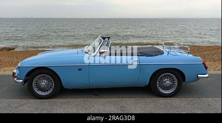 Classic Light Blue MG Roadster voiture garée sur la promenade du front de mer avec mer en arrière-plan. Banque D'Images