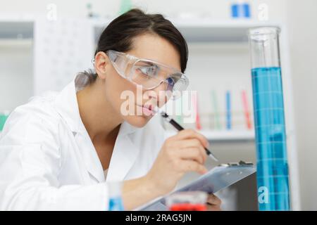 femme médecin travaillant avec le presse-papiers en laboratoire Banque D'Images
