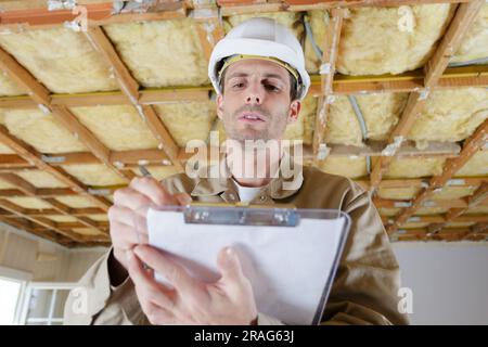 Homme builder writing on clipboard Banque D'Images