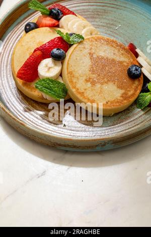 crêpes moelleuses avec des fruits sur un matin ensoleillé Banque D'Images