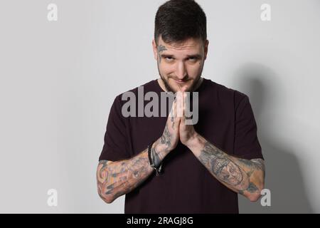 Portrait de l'homme de taille basse avec les mains clashed sur fond gris clair Banque D'Images