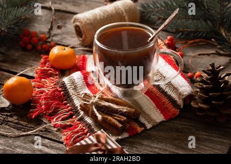 tasse avec café à côté d'une branche d'un arbre de noël mandarine cannelle sur une table en bois, table de noël avec café le matin Banque D'Images