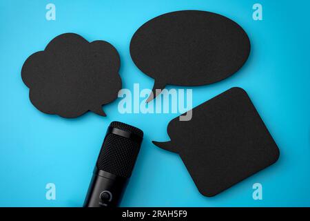 Microphone et bulles de parole vierges isolées sur le bleu avec concept d'espace de copie pour la diffusion audio média radio, le chat dans les podcasts, l'engagement audio Banque D'Images