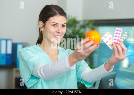emale médecins tenant la pomme et le bouquet de comprimés Banque D'Images