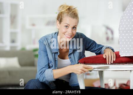 femme travaillant sur une chaise en bois Banque D'Images