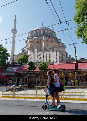 Deux hommes montent en scooter près de la mosquée Laleli, un bâtiment ottoman du 18e siècle à Laleli, quartier de Fatih, Istanbul, Turquie. Banque D'Images