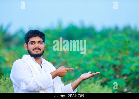 Agriculteur indien tenant le coton en main, heureux et jeune agriculteur Banque D'Images