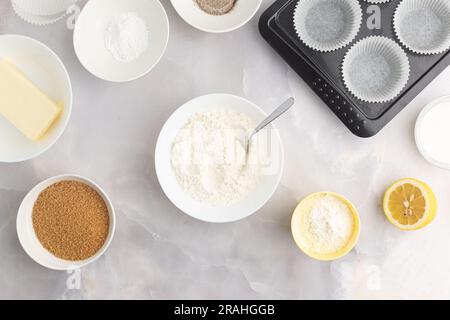 Divers ingrédients de cuisson - farine, sucre, beurre et ustensiles de cuisine sur fond gris. Vue de dessus. Banque D'Images