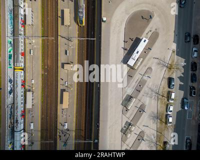 Photo aérienne de haut en bas du centre de transport de la gare montrant les différents trains stationnés les uns à côté des autres sur les rails à côté des quais, et les bus attendant dehors. Photo de haute qualité Banque D'Images
