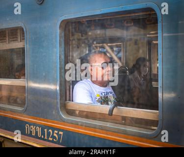 Homme avec des lunettes de soleil voyageant sur les chemins de fer thaïlandais de la gare de Hua Lamphong à Bangkok Banque D'Images